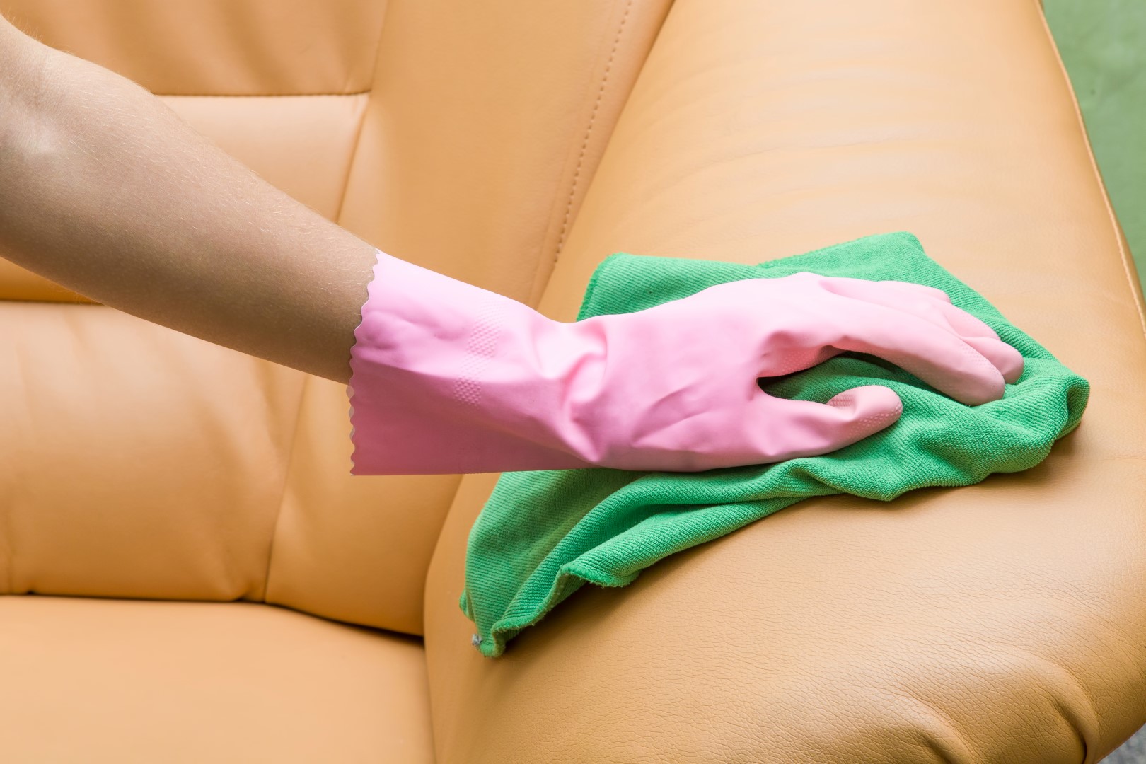 Fotografía realizando la limpieza y mantenimiento de un sofá tapizado con polipiel